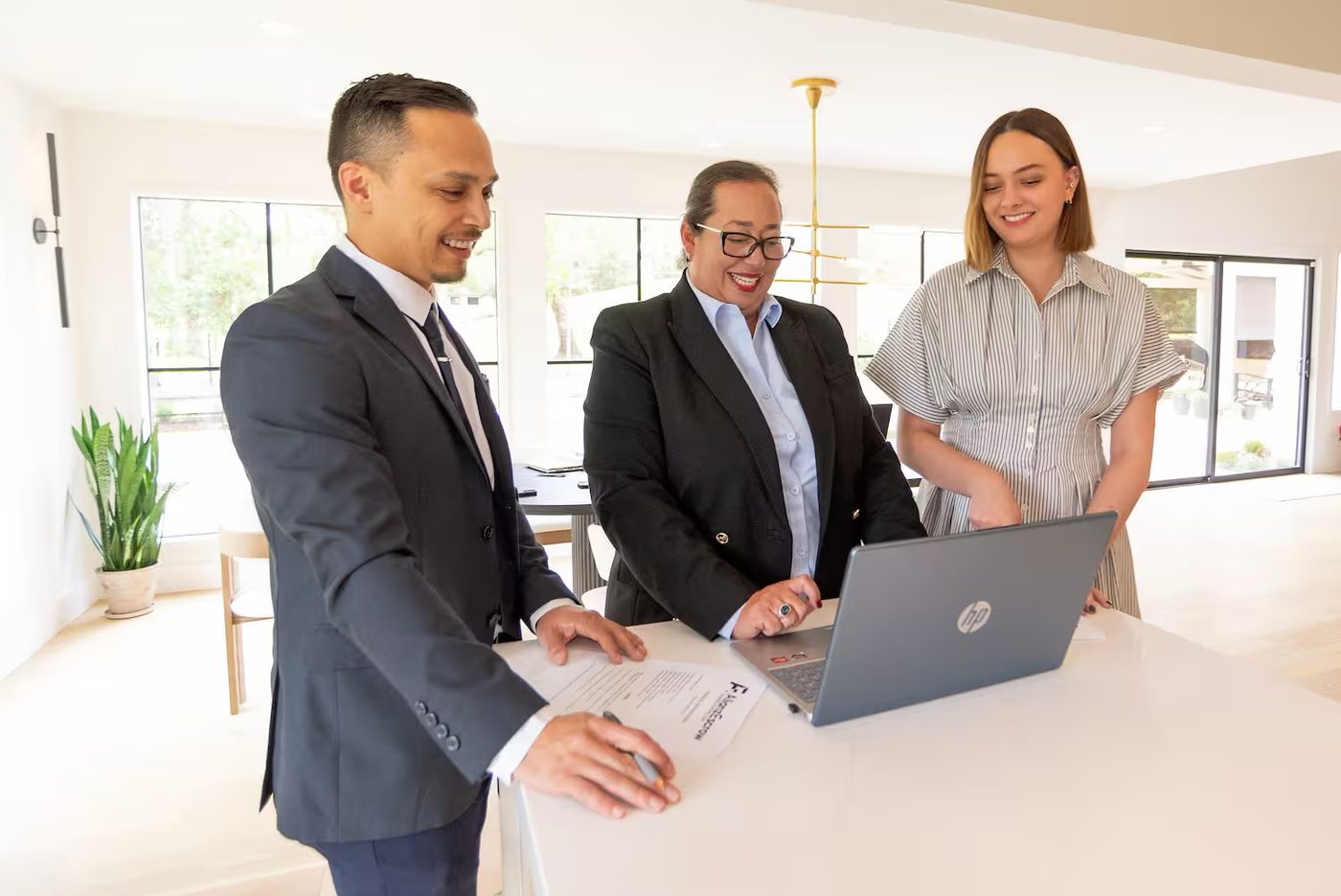 AlianzEscrow representatives reviewing closing documents with a client